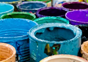 Vendor Directory A vivid assortment of open paint cans displaying a spectrum of colors, ideal for artistic and design projects.